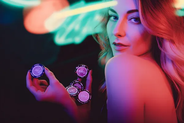 A glamorous woman holding casino chips in a neon-lit environment, representing the premium online casino atmosphere of 10WIN.